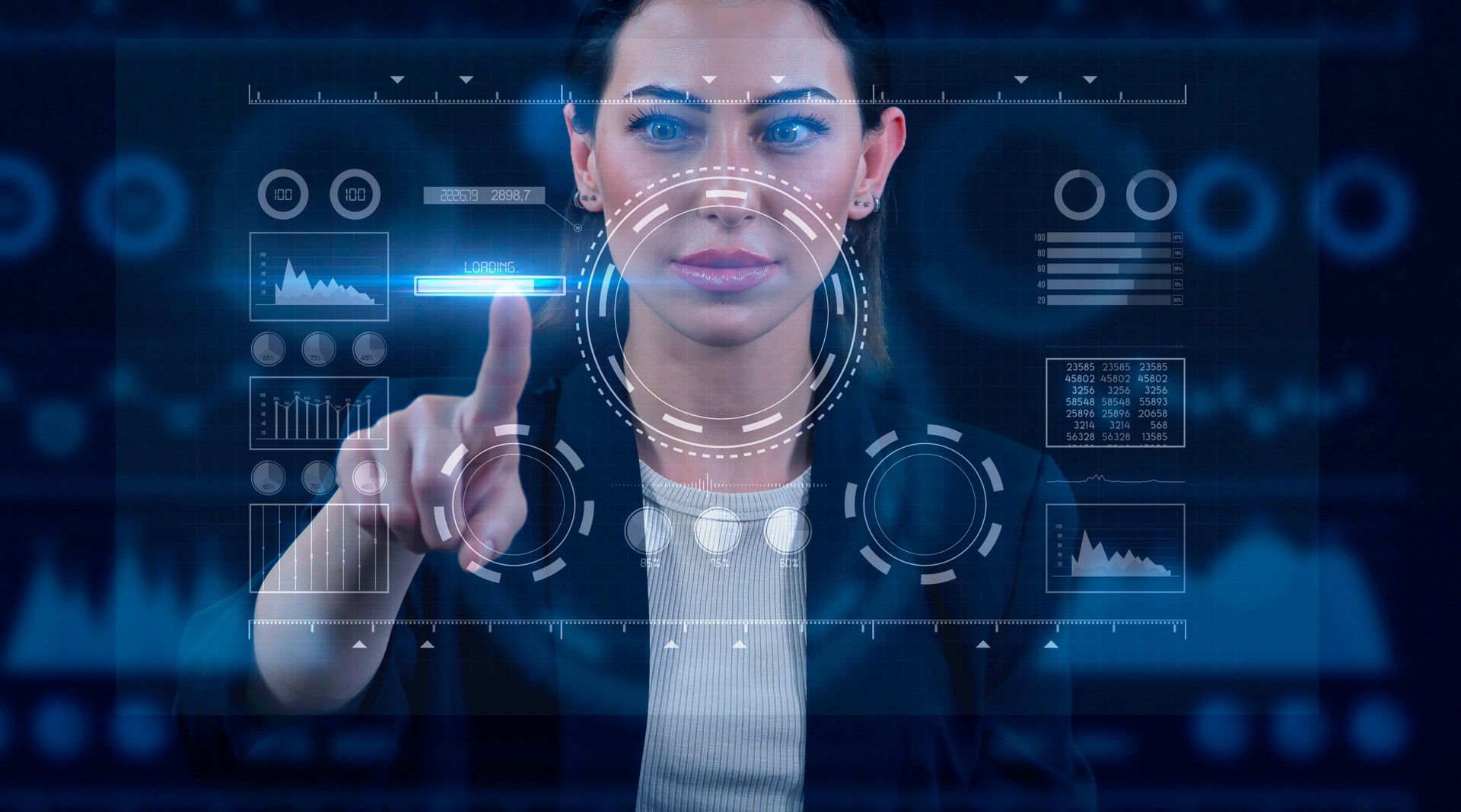 View of a young businesswoman who is reviewing the analytics on a blue hologram. Graphical User Interface.